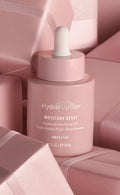 Pink HydroPeptide Moisture Reset skincare bottle with dropper on background of pink boxes